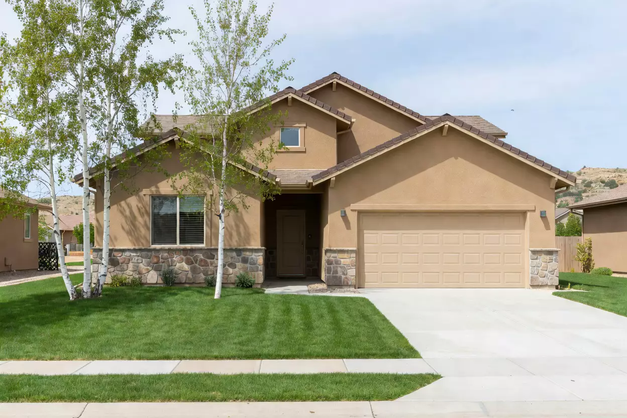 Tan stucco two-story house with birch trees